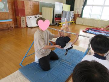 鉄棒で足抜き回りをしている様子